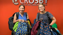 Two staff pose with backpacks