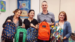 Group of staff pose with backpacks