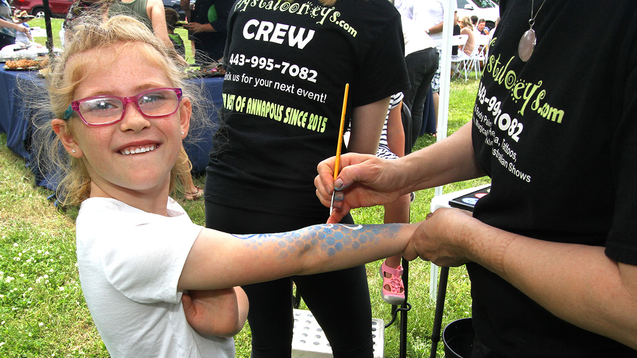 Young girl gets her arm painted