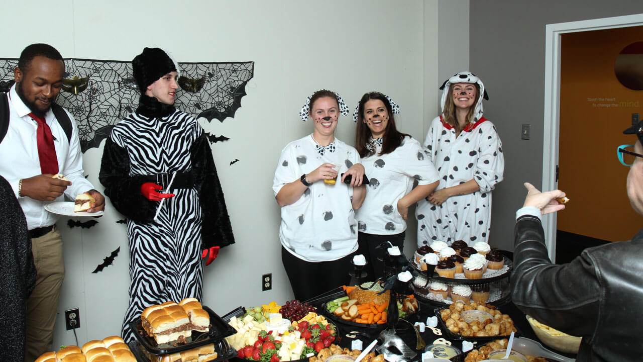 Staff dressed as Cruella DeVille and puppies at Boo Bash